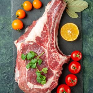 top-view-fresh-meat-slice-with-tomatoes-dark-blue-background-food-meat-kitchen-animal-cow-butcher-chicken-color_179666-46016